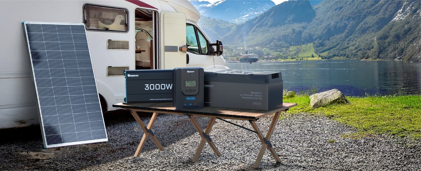 Renogy portable solar panel kit with an inverter and lithium battery set up beside a camper van by a lake