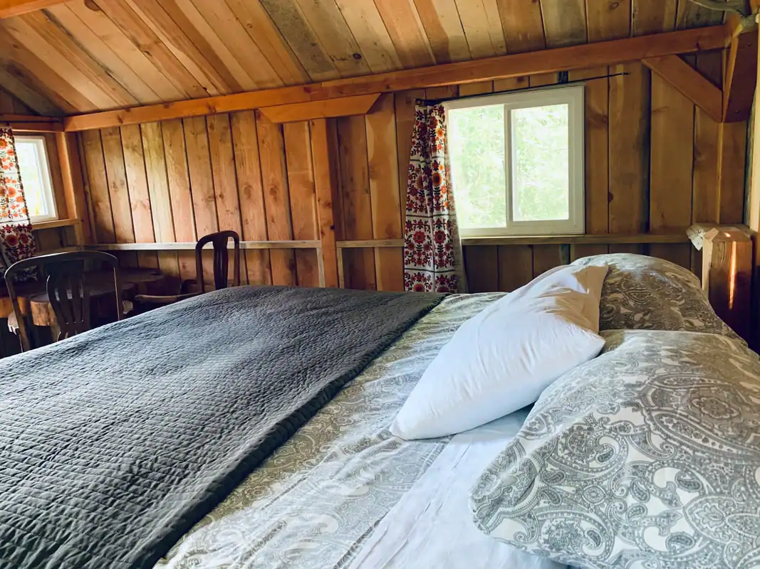 Close-up of the king bed with white linens in the King Wood Cabin