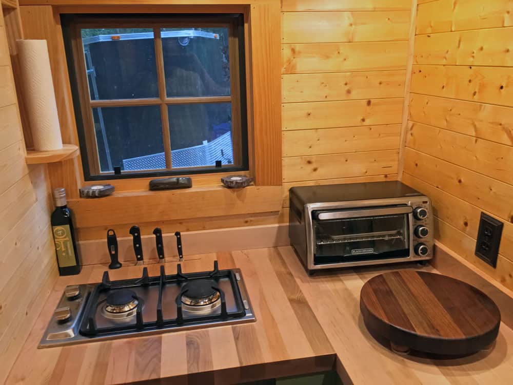 Two-burner stainless propane cooktop with a built-in knife block and toaster oven on butcher block counters