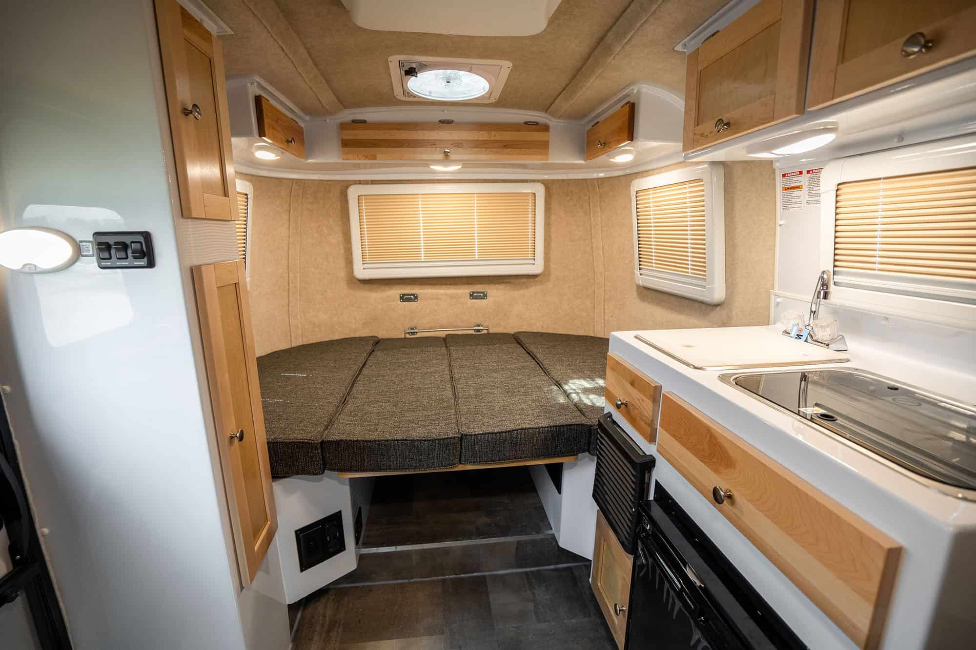Interior looking at the rear cushions, sink and stove to the right