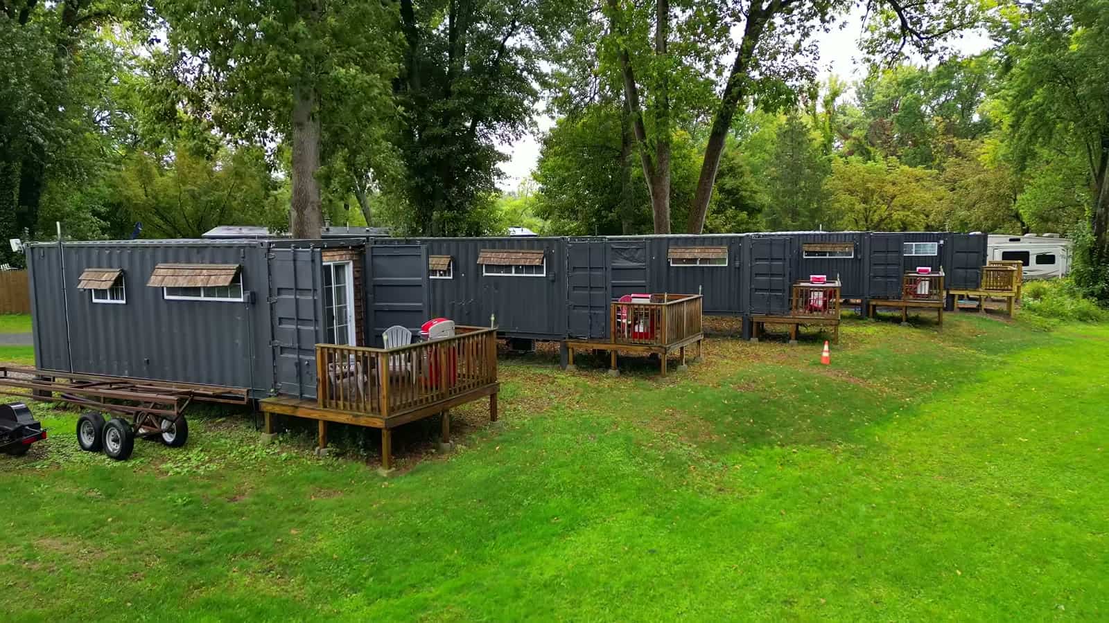 Long row of container cabins with private wood decks and Adirondack chairs