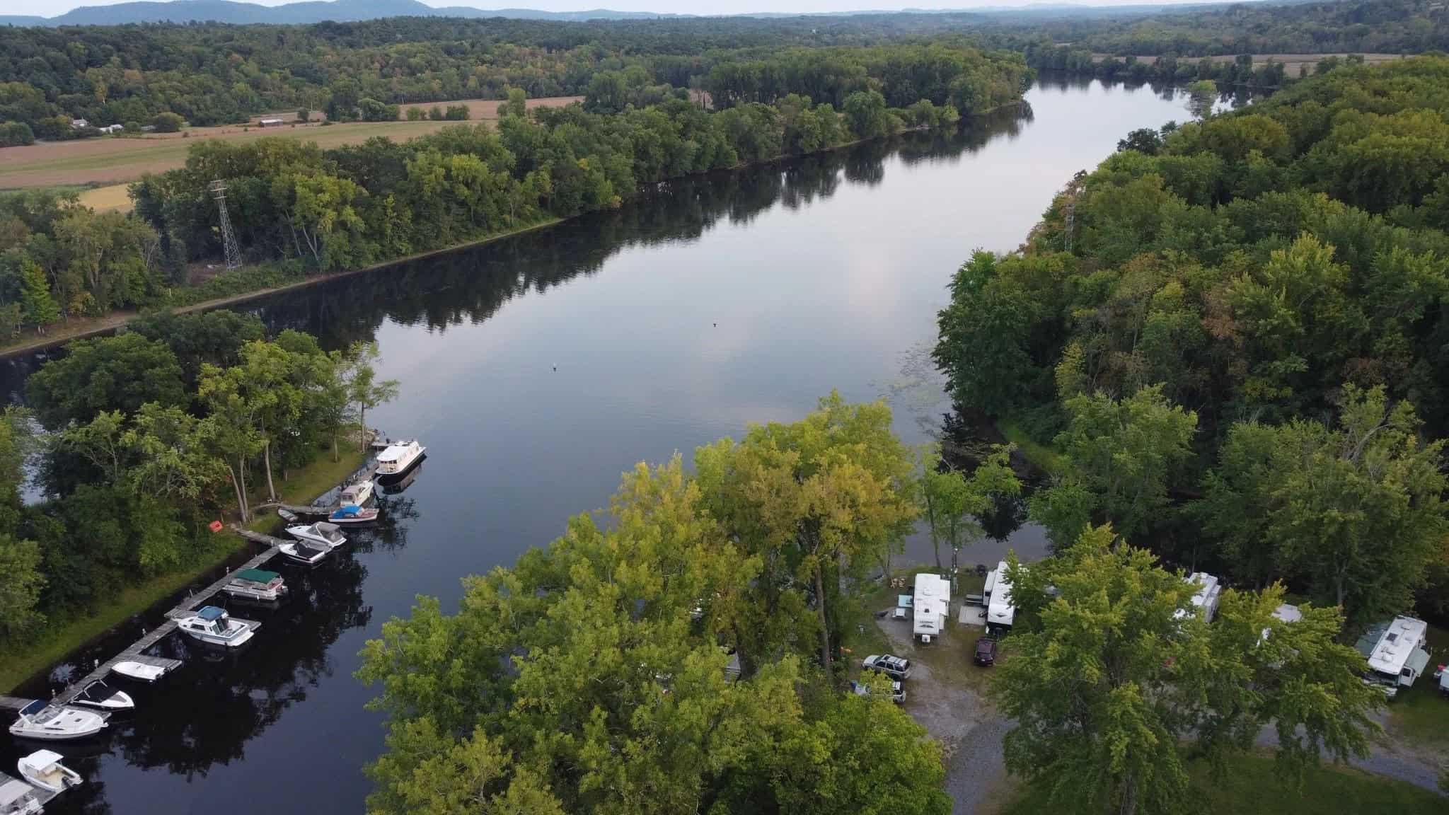 Aerial view of Schuyler Yacht Basin marina docks and RV sites on the Hudson River and Fish Creek