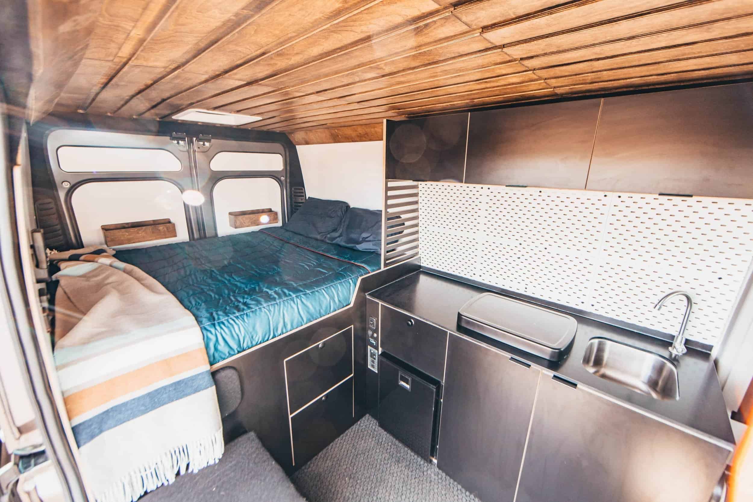 Small tiny house interior with bed and kitchenette in a cozy space.