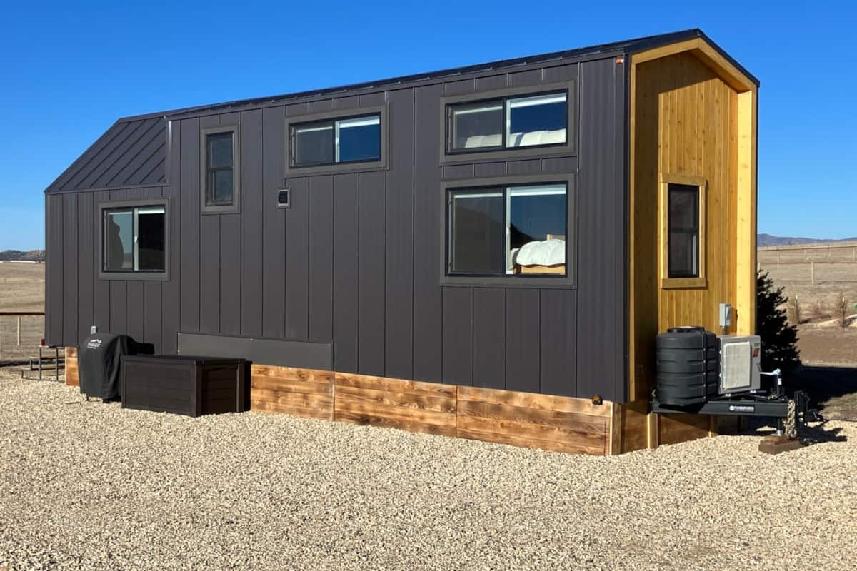 Modern tiny house with sleek black exterior and wooden accents, perfect for small space living.