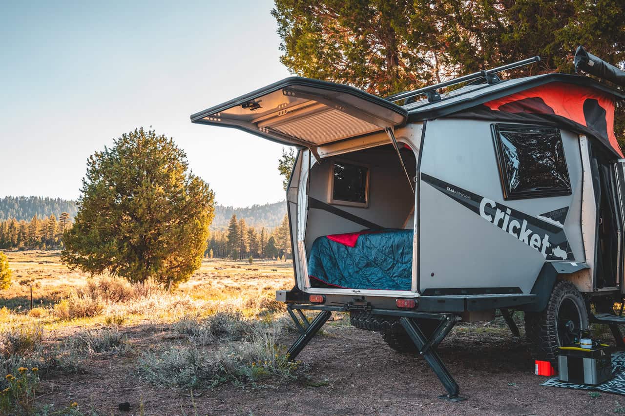Compact tiny house with outdoor storage and fold-out deck for outdoor living.