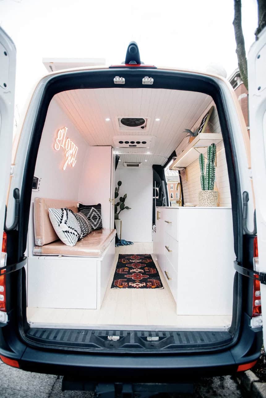 Cozy tiny house interior featuring built-in seating, decorative pillows, and stylish storage solutio.