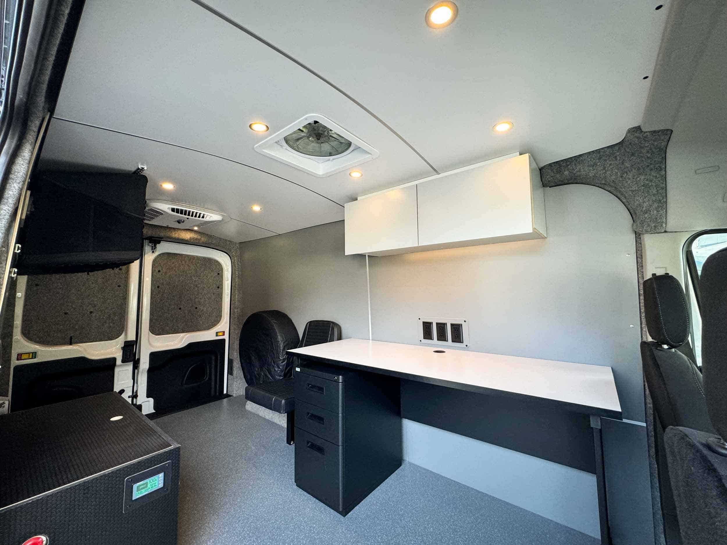 Compact tiny house interior with workspace, storage, and seating for efficient small space living.