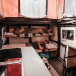 Cozy tiny house interior with multi-level sleeping bunks and compact kitchen space.