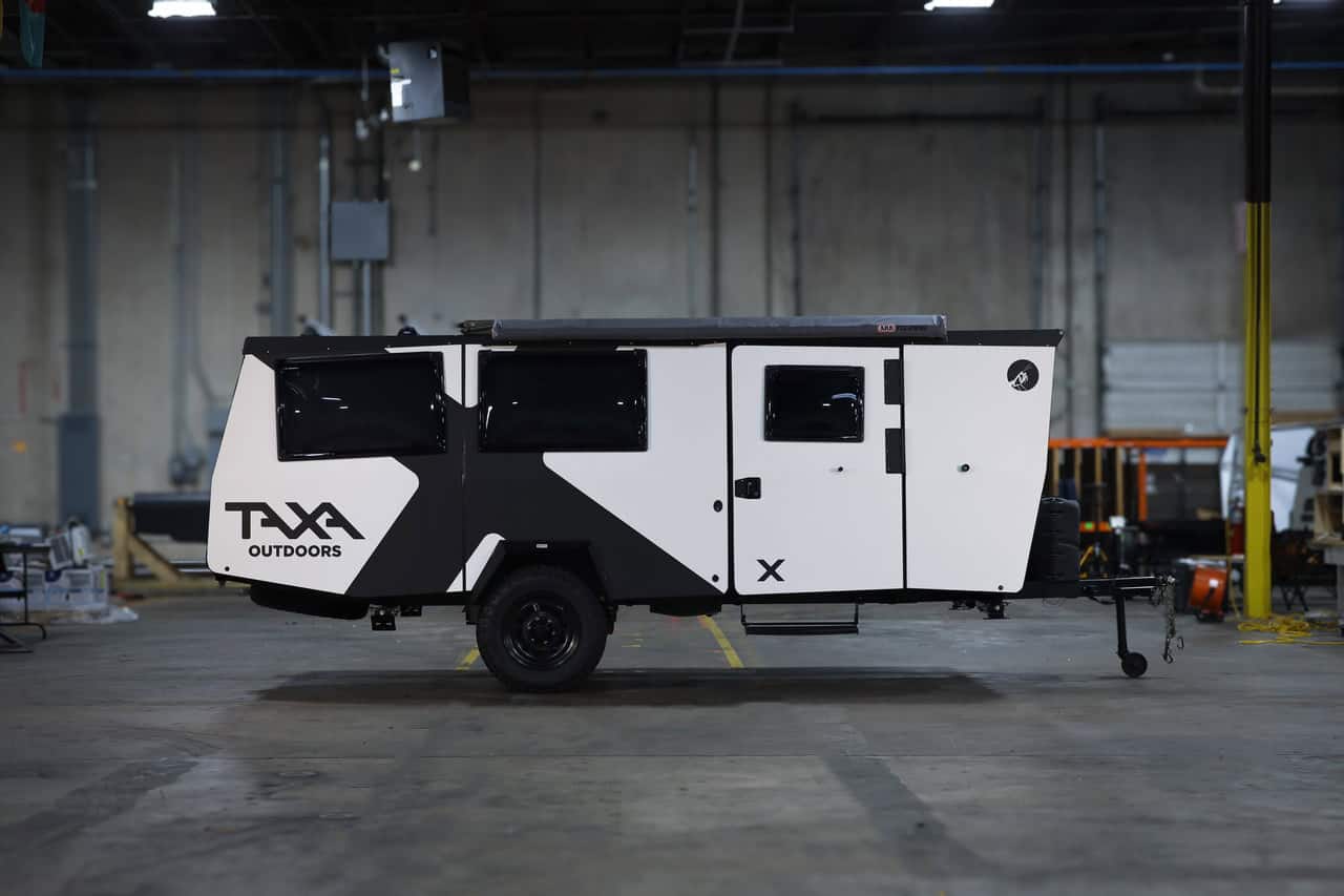 Off-grid tiny house trailer with black and white exterior, designed for small space living and outdo.