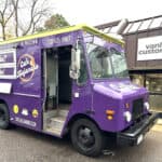 Colorful purple food truck with "Cafe Mocha" branding parked outside a building.