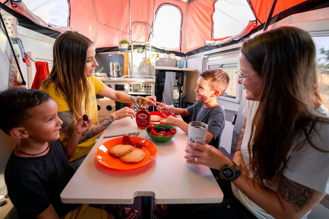 Cozy tiny house interior with family enjoying a meal at a small table.