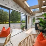 Bright tiny house interior with large glass sliding doors and skylights, showcasing a modern, airy l.