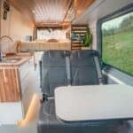 Compact tiny house living space with modern kitchen and seating area.