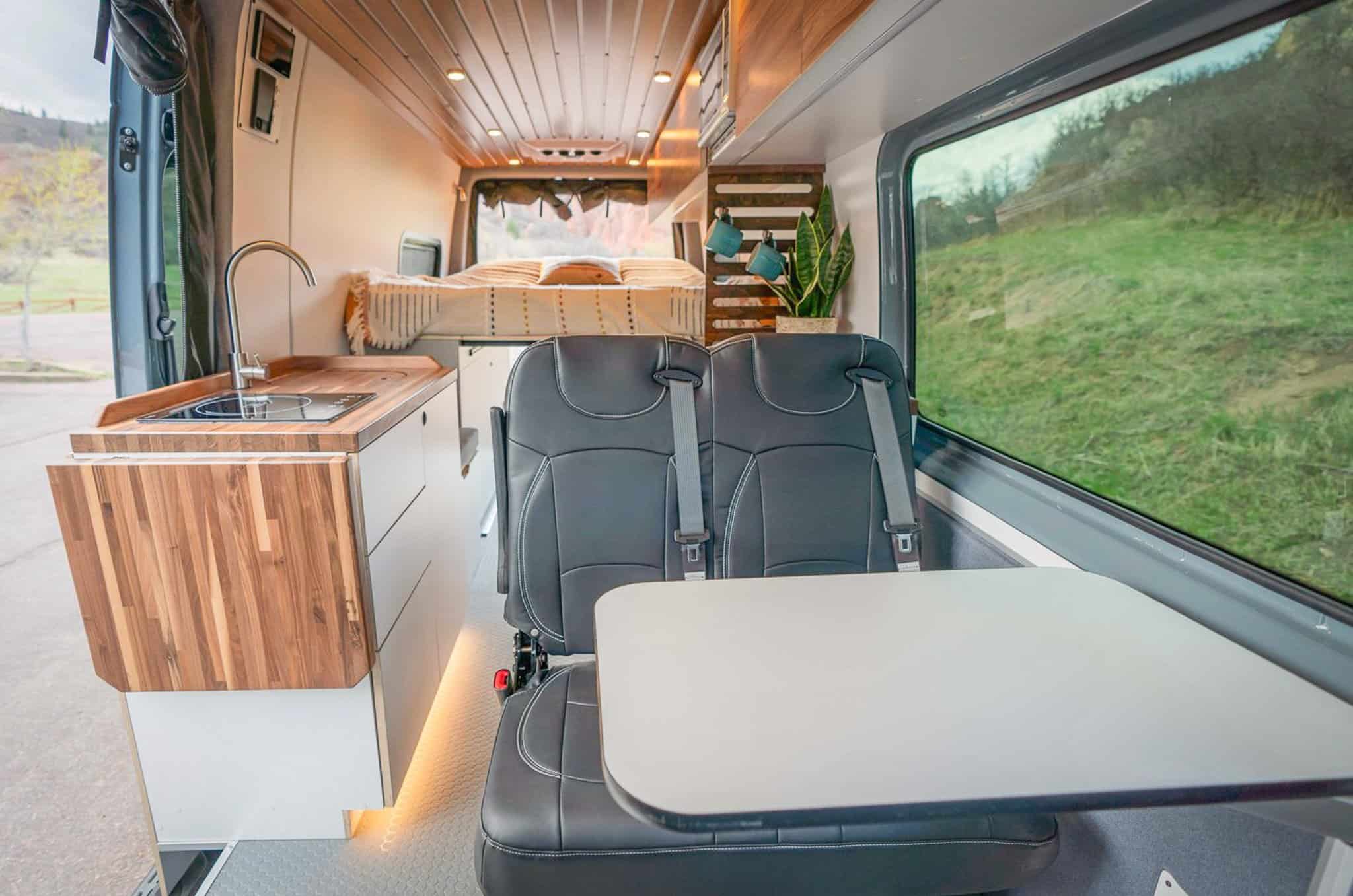 Compact tiny house living space with modern kitchen and seating area.