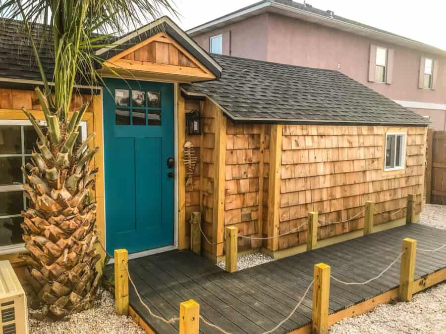 Cozy tiny house with vibrant blue door and natural wood siding, perfect for small space living.