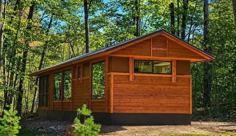 Shoreline cabin exterior with cedar siding among the trees at Canoe Bay Village Lot 19