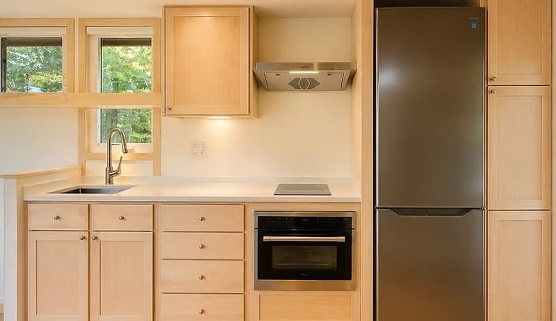 All-electric kitchen with stone counters, induction cooktop, wall oven, and a tall fridge/freezer at the Shoreline Lot 17