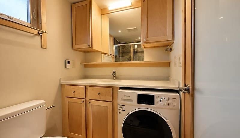 Bathroom with a stone vanity and a built-in washer/dryer at the Shoreline Lot 17