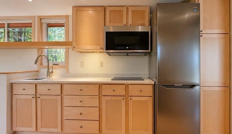 Interior view toward the all-electric kitchen and lake-facing windows of the Shoreline Lot 19