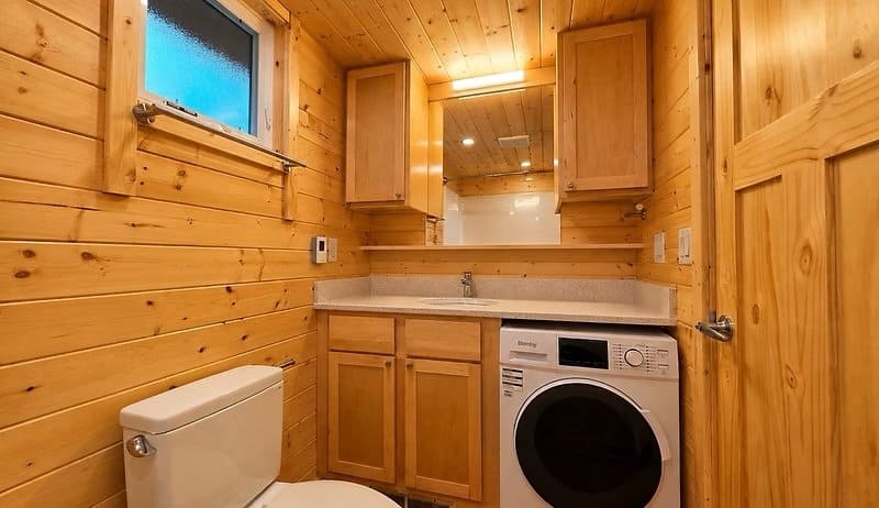 Bathroom vanity with quartz top and a built-in washer and dryer at the Shoreline Lot 23