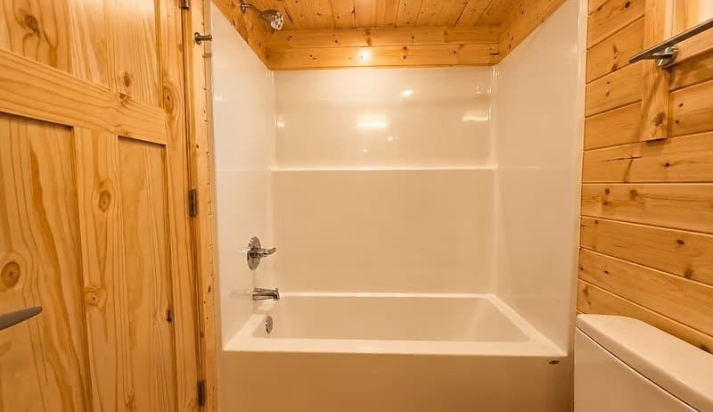 Bathroom with a tub and shower combo set against warm cedar walls at the Shoreline Lot 23