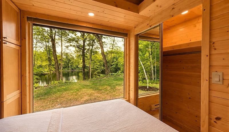 King bedroom with a floor-to-ceiling corner window looking out to the water at the Shoreline Lot 23