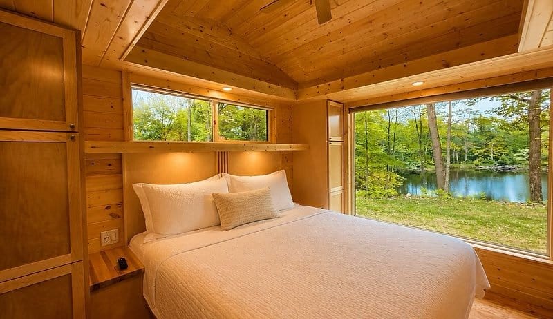 King bedroom with vaulted ceiling and floor-to-ceiling glass framing Lost Lake at the Shoreline Lot 23