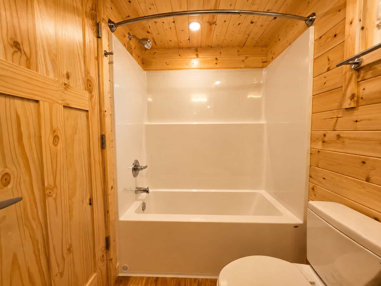 Bathroom tub and shower surround with knotty pine walls at Shoreline Lot 24