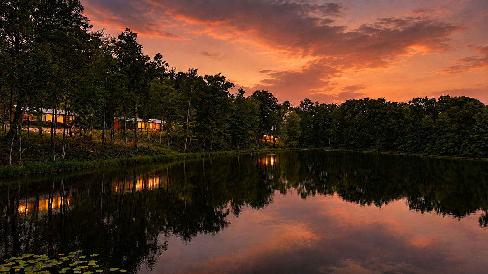 Lost Lake at dusk with Shoreline cabins glowing among the trees at Canoe Bay Village