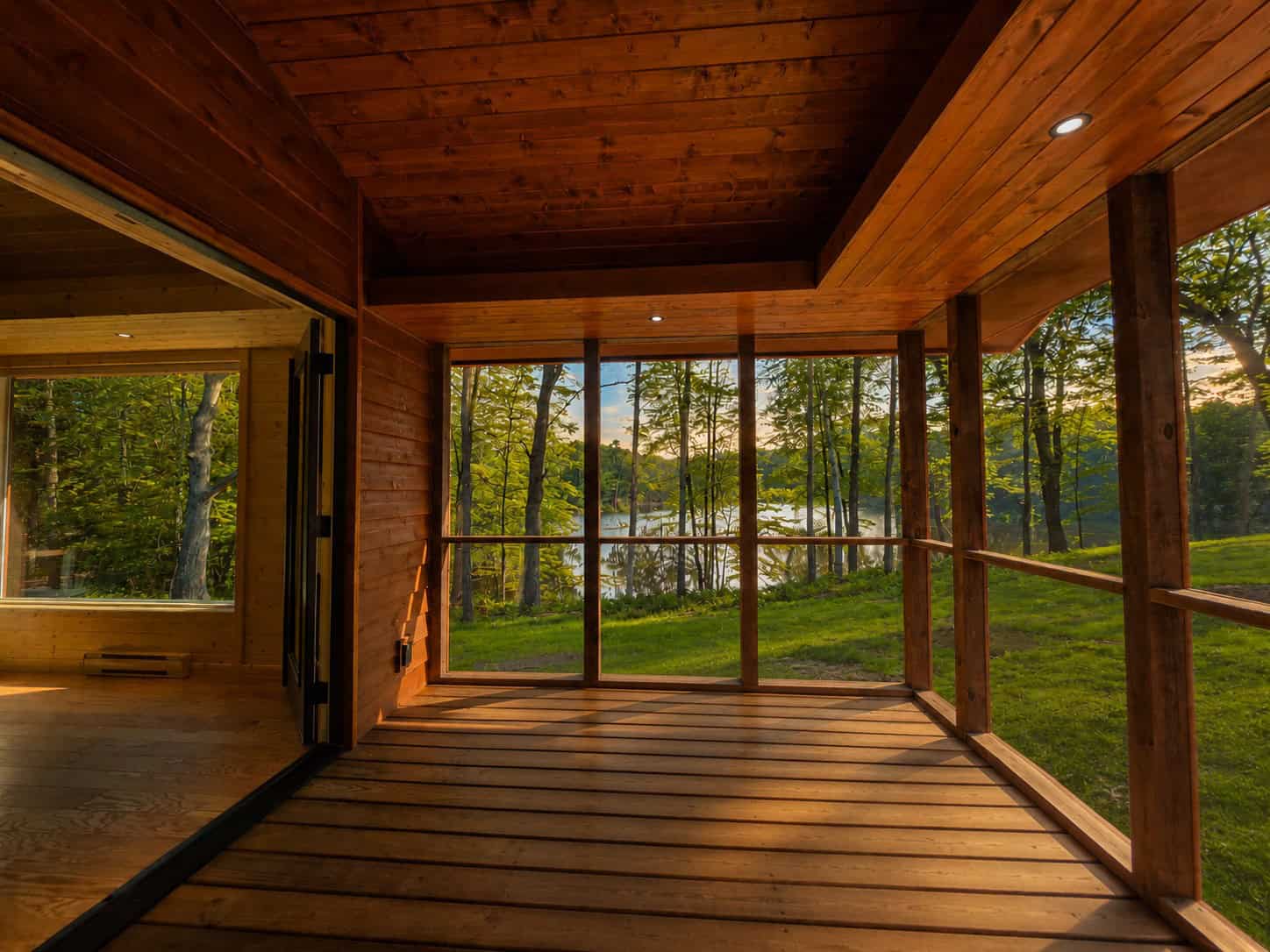 Spacious wood screened porch looking out over the lawn and Lost Lake at Shoreline Lot 24