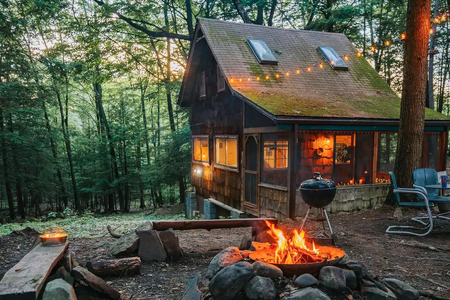 Charming tiny cabin nestled in the woods with outdoor fire pit and cozy ambiance.