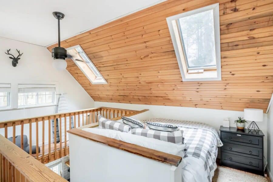 Charming small cabin bedroom with sloped wooden ceiling and skylights in the Catskills. Perfect retr.