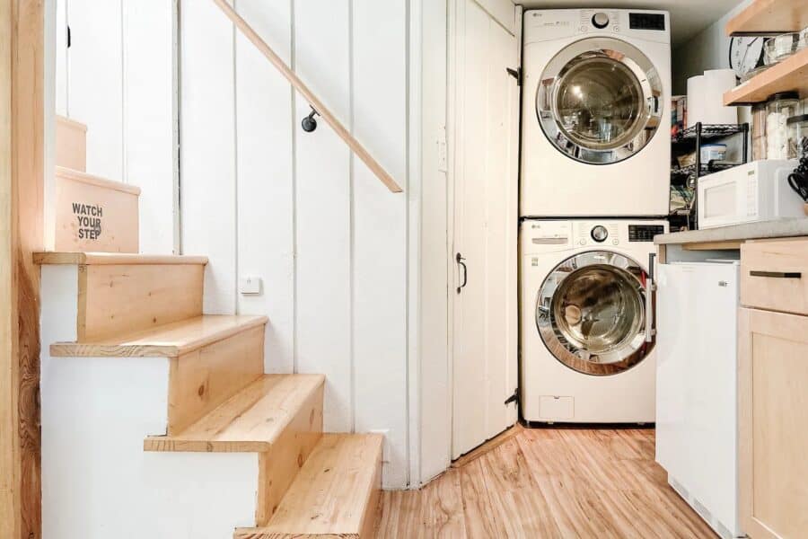 Compact laundry nook with stacked washer and dryer in a small cabin.