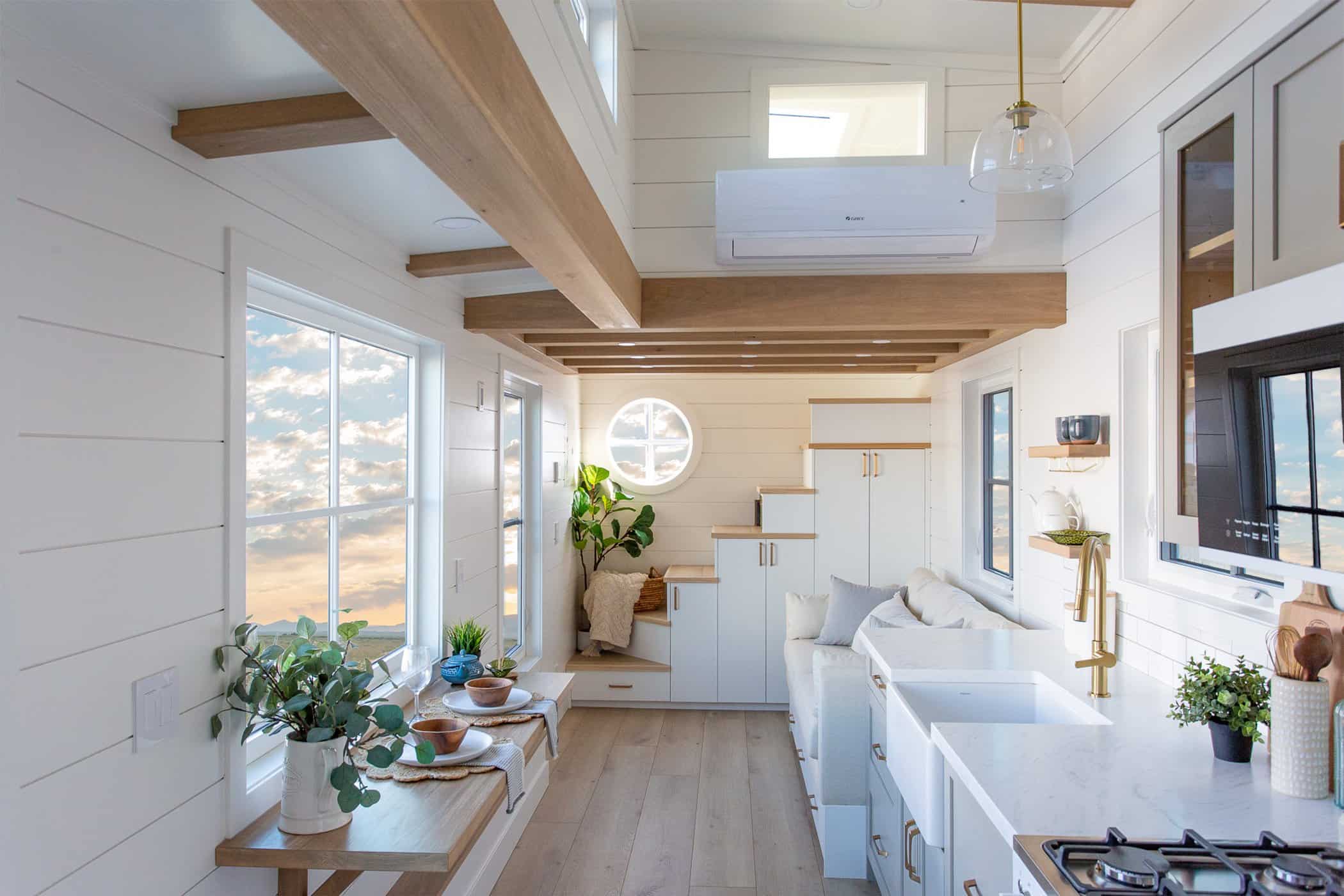 Summit Boho living and kitchen toward stairs: white shiplap, wood beams, galley and loft stairs ahead