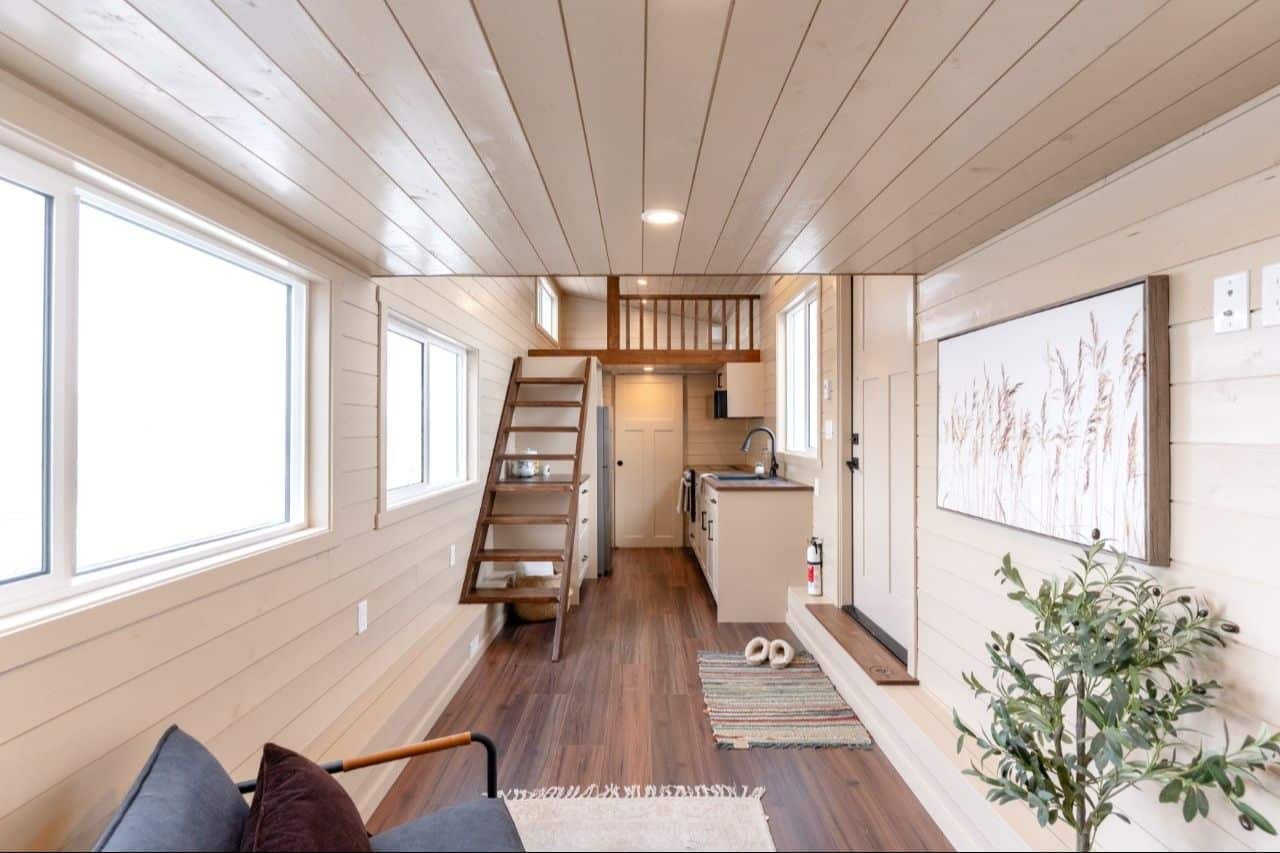 Looking down the 2026 Ruby aisle: three side windows, cream kitchen, dark stair and loft, closed door at the far end