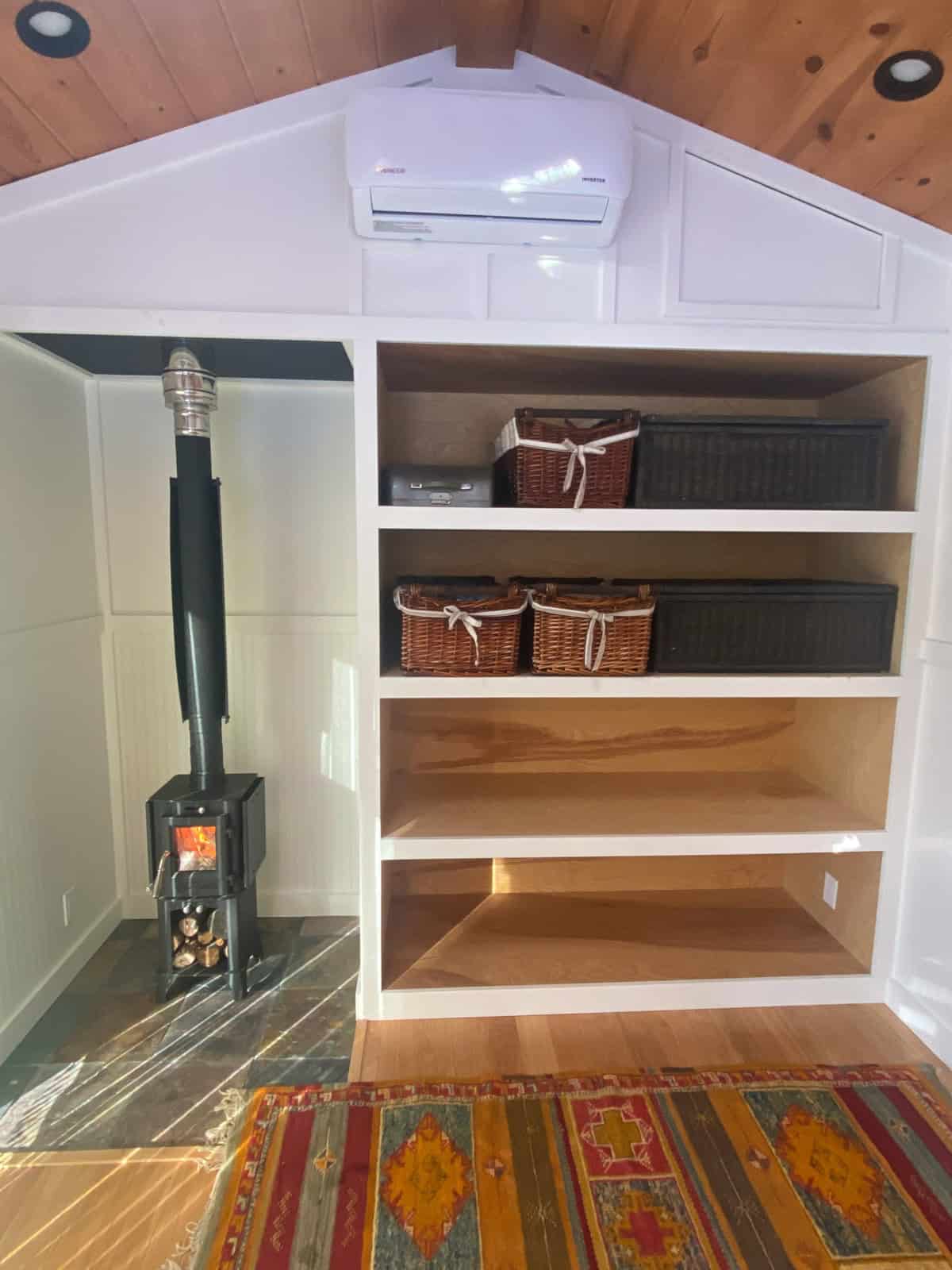 Efficient small space storage with built-in shelves and baskets in a tiny house.