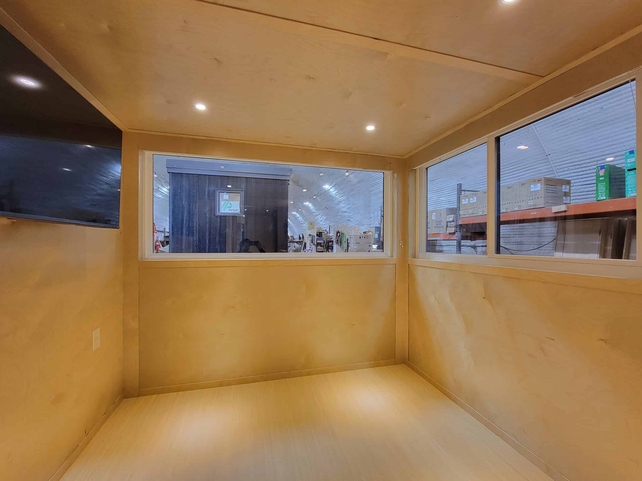 Interior of a tiny house showcasing spacious design and large windows for natural light.