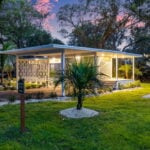 Cozy tiny house featuring a sleek, contemporary style surrounded by lush greenery. Perfect for minim.