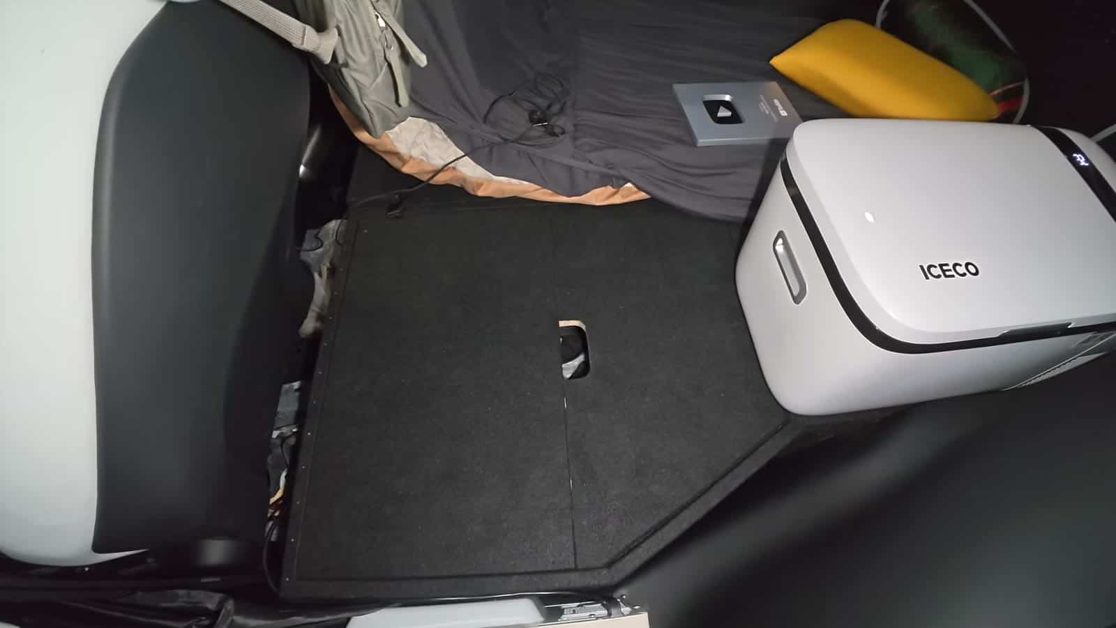 ICECO portable fridge installed beside the bed platform in a Tesla Model X