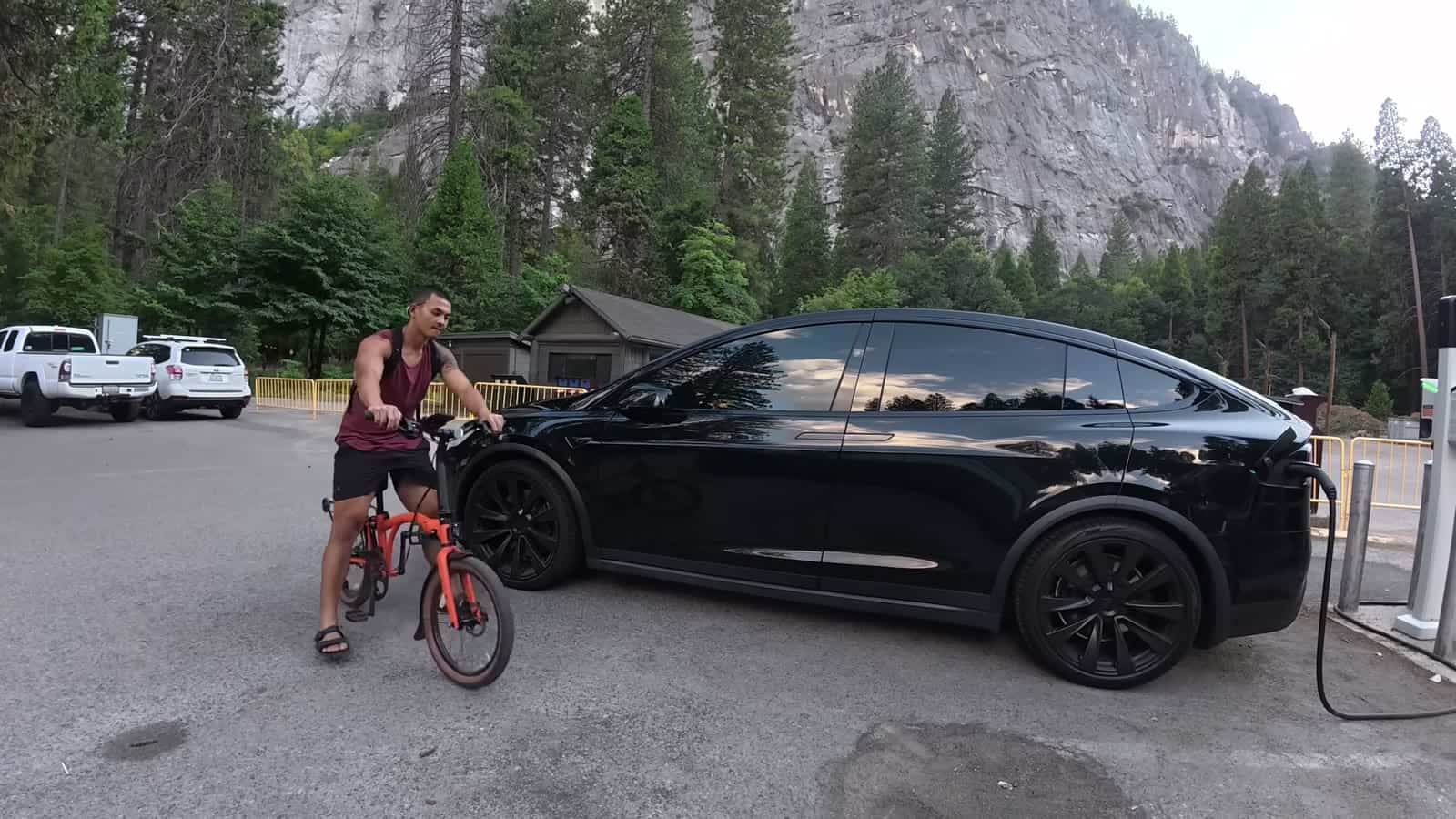 Nico Murillo with his e-bike next to his Tesla Model X at a charging station in Yosemite