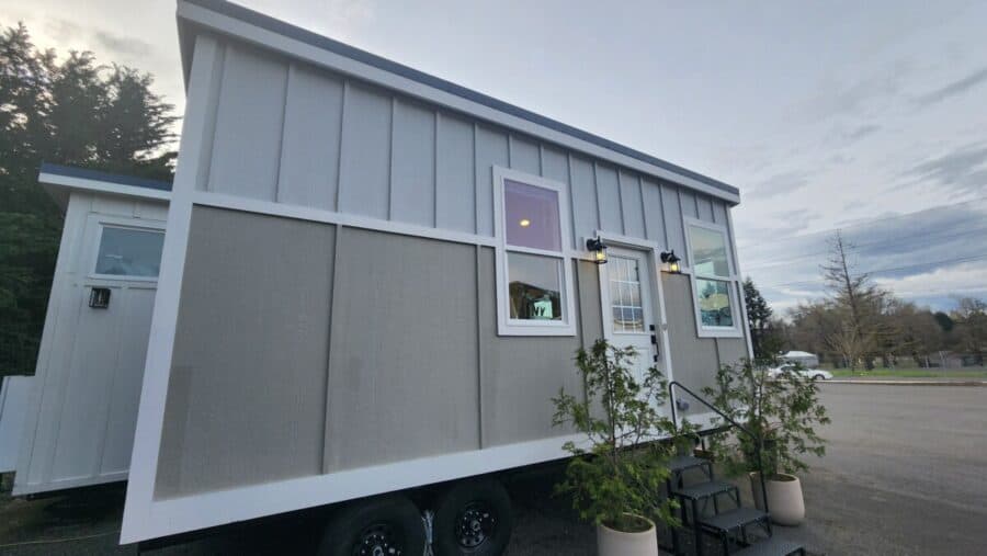 Compact tiny house on wheels with modern design and large windows. Perfect for small space living or.