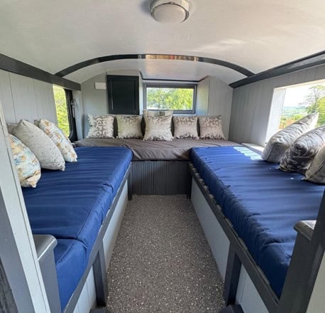 Snug with blue daybeds along both sides and a window at the end