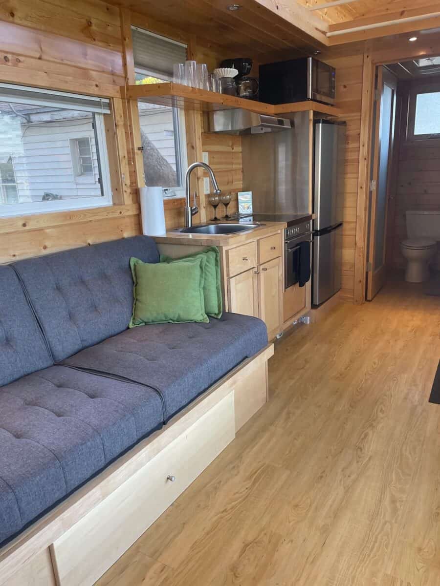 Compact tiny house interior with kitchen, sofa, and wooden accents in Orlando, Florida.