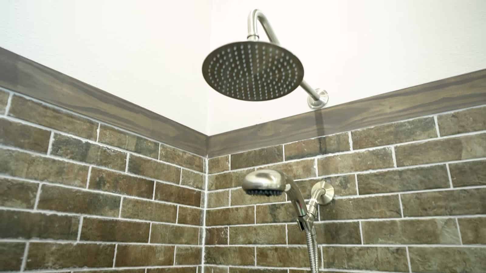 Walk-in shower with brick-look tile, rainfall shower head and handheld sprayer