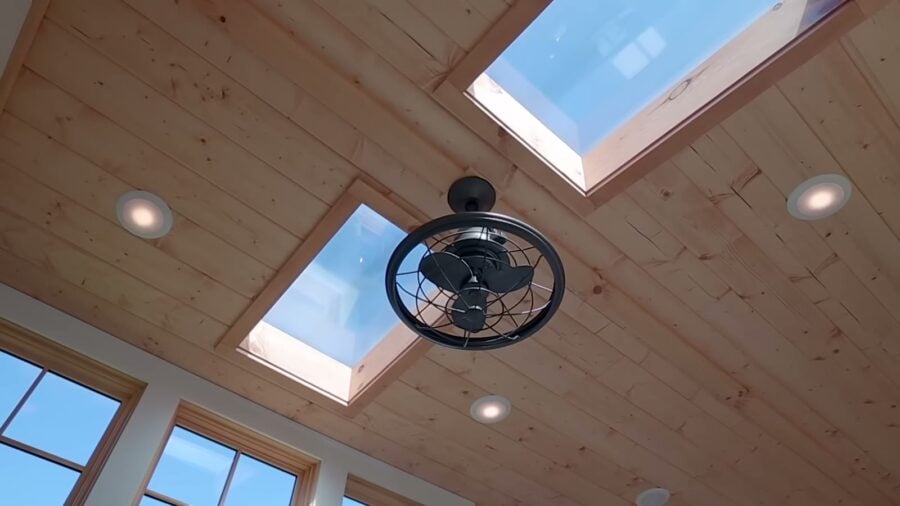Two skylights and an oscillating ceiling fan in the pine-clad living room ceiling