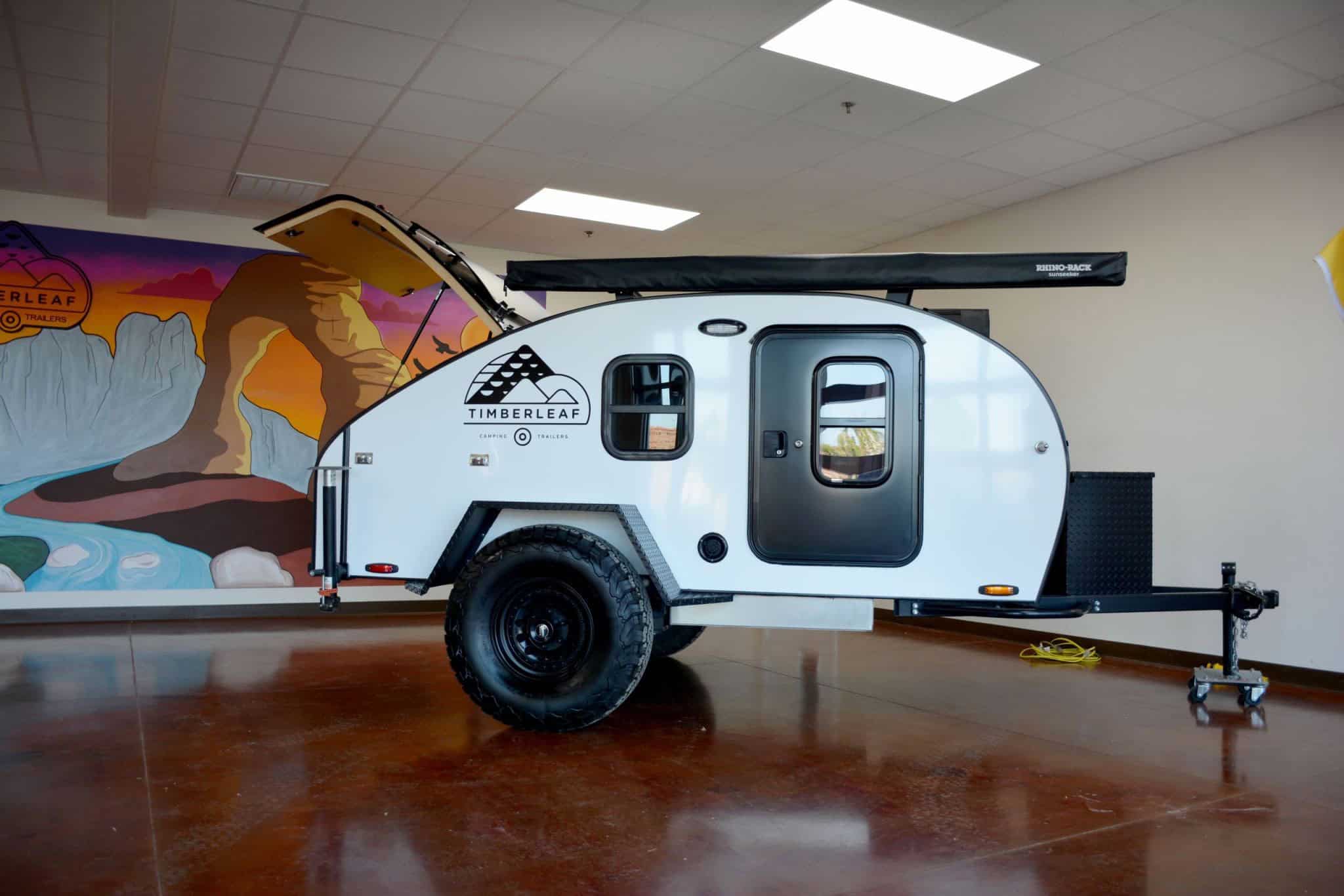 White Timberleaf Classic teardrop with rear galley hatch open in the Timberleaf showroom