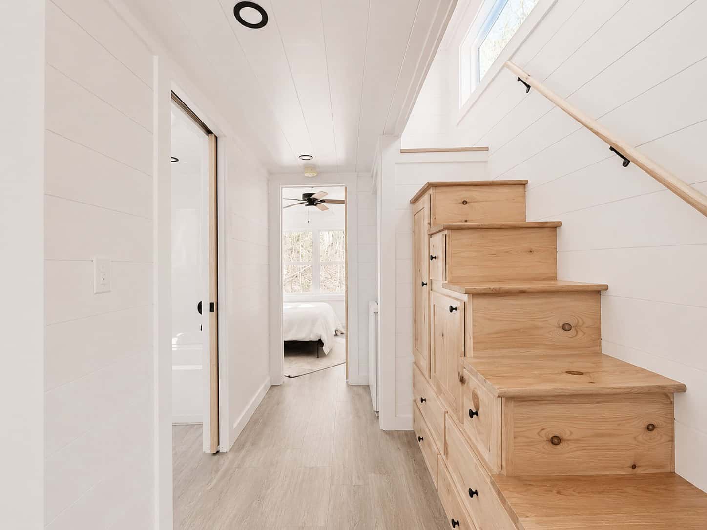 Hall with a wood storage staircase on the right and a bedroom visible at the far end