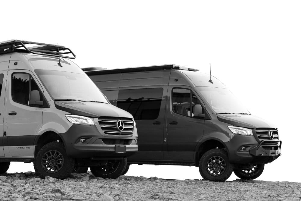 Two Titan Vans Mercedes Sprinter camper conversions parked side by side on rock, roof racks and off-road tires