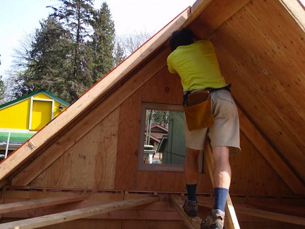 Travis Roofing his Prefab Tiny Cabin