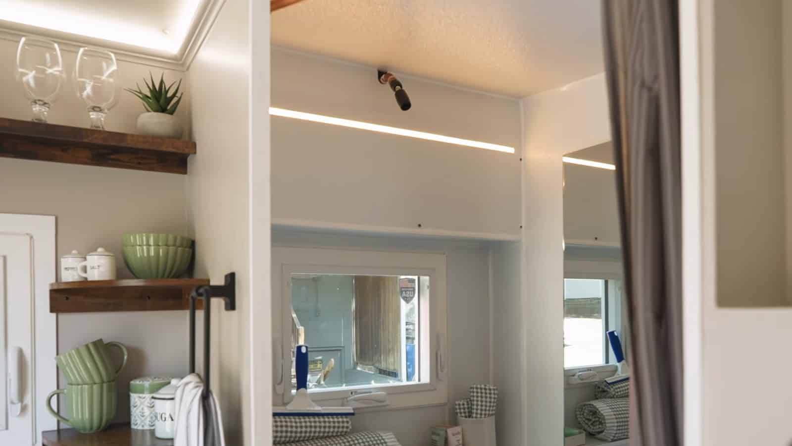 Bathroom area inside the Uplift Micro Home with shower, mirror and shelving